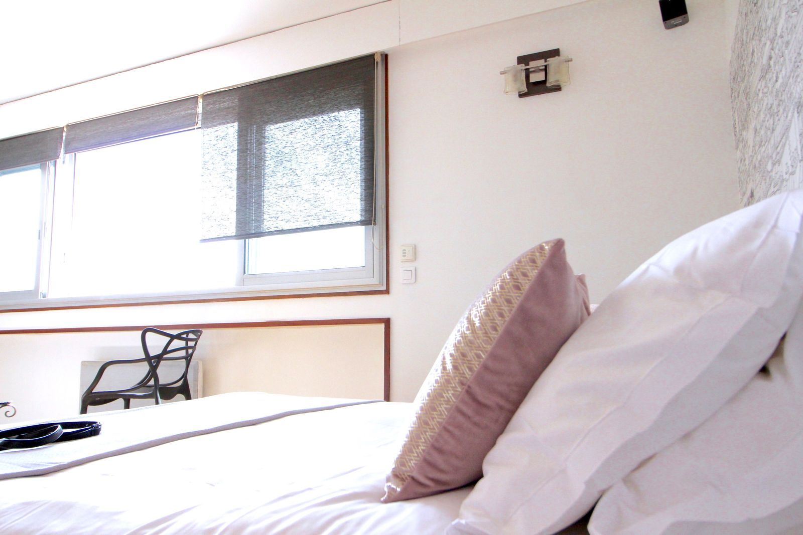 Gros plan du lit avec oreillers et lumière naturelle