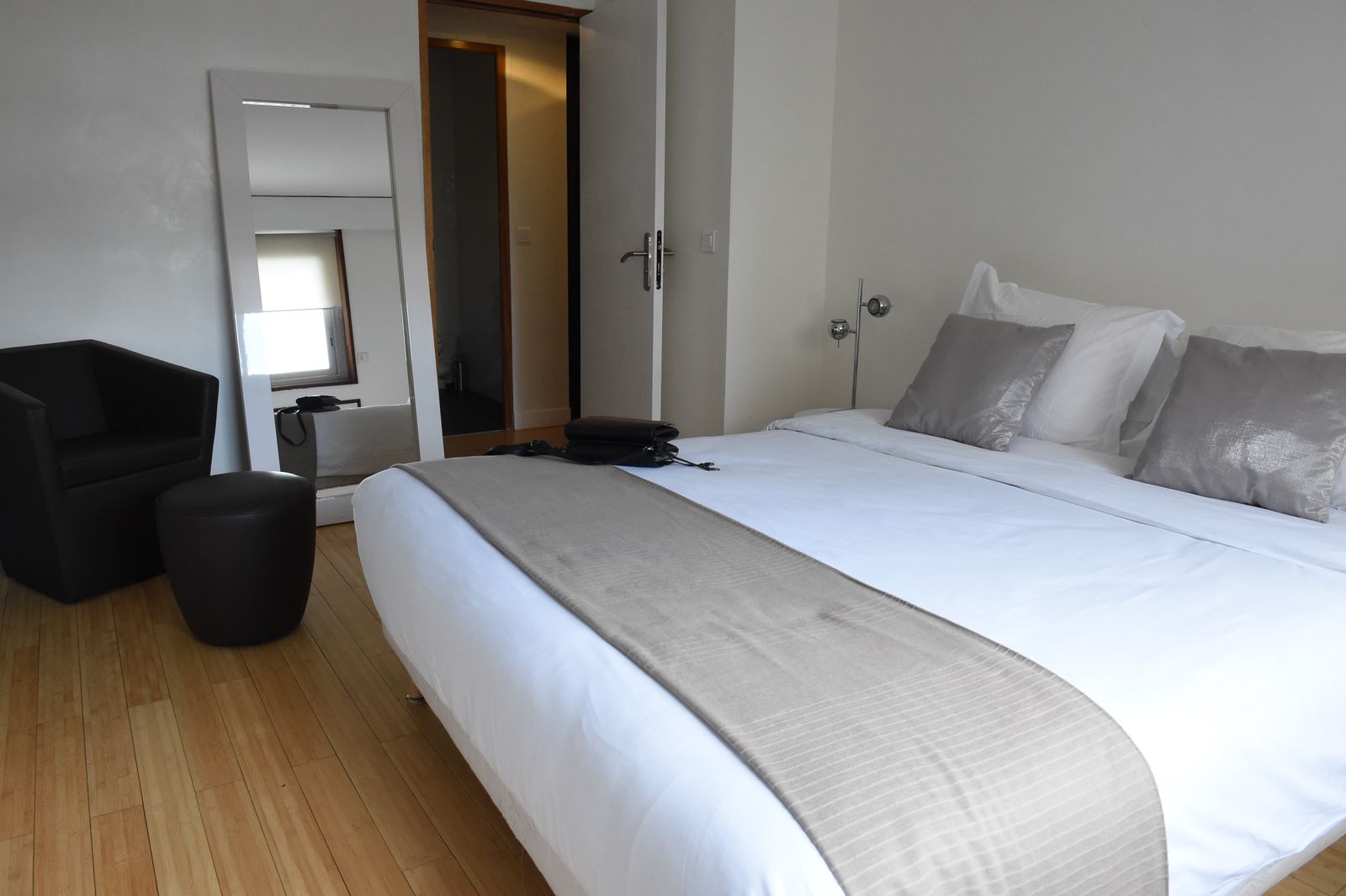 Chambre avec fauteuil et parquet au sol