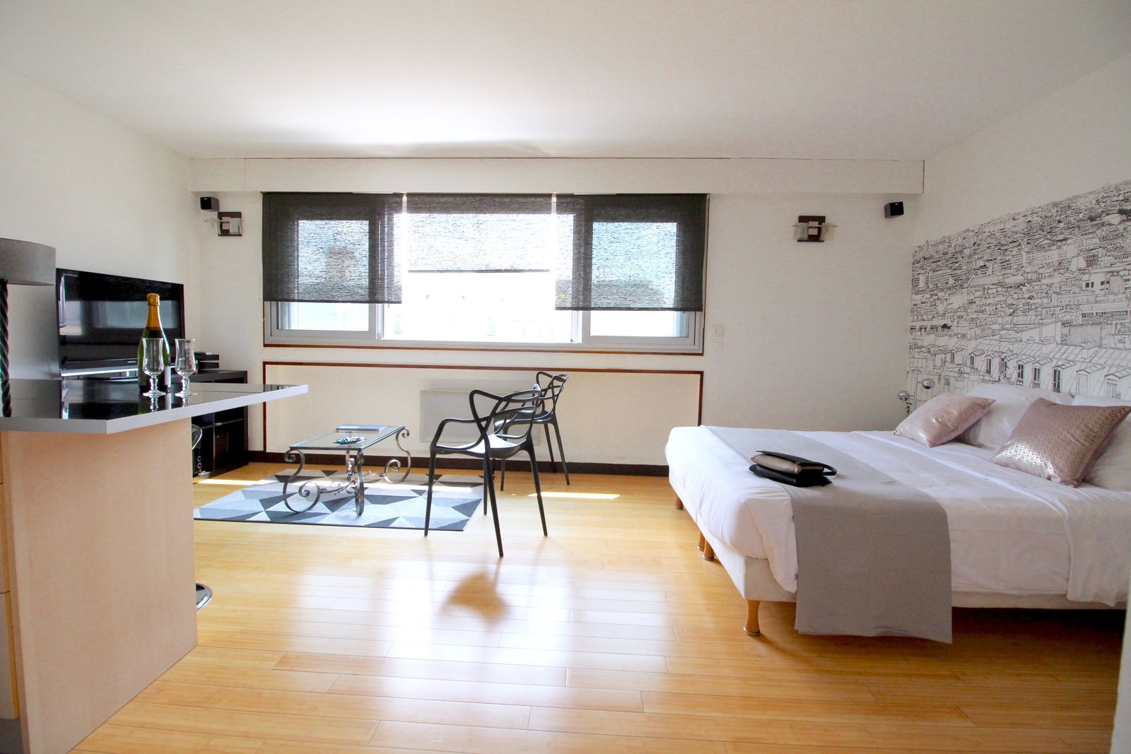 Vue large du studio avec espace salon et parquet