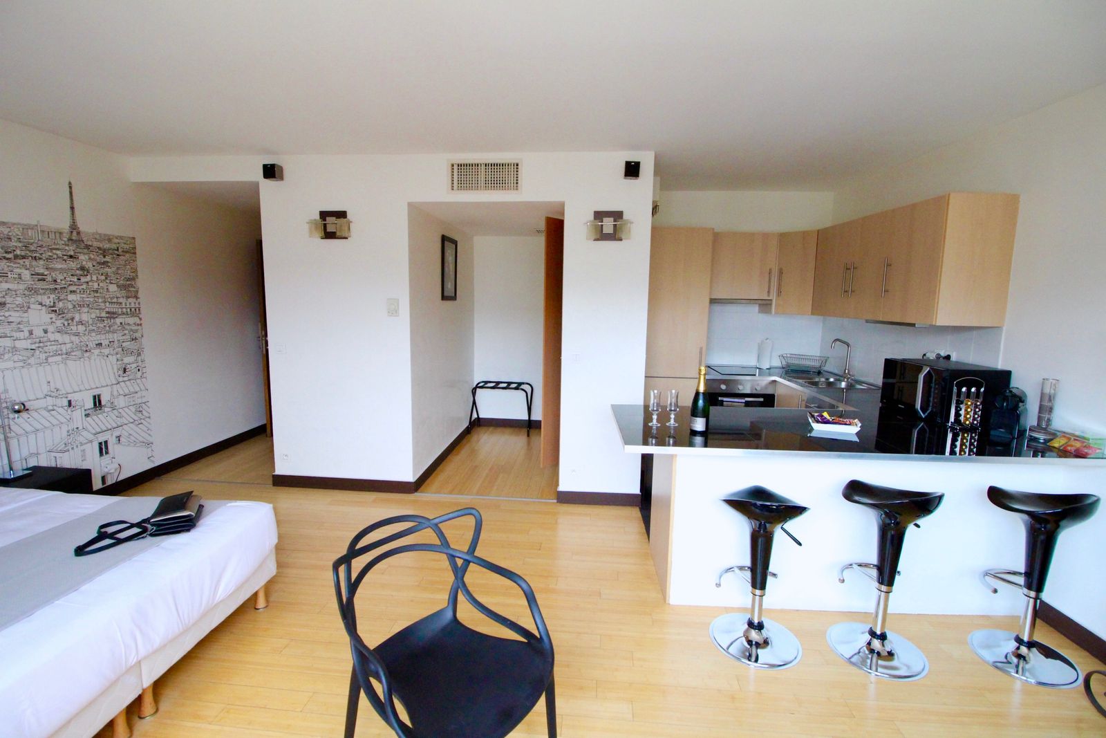 Bar cuisine avec tabourets noirs et vue sur le lit